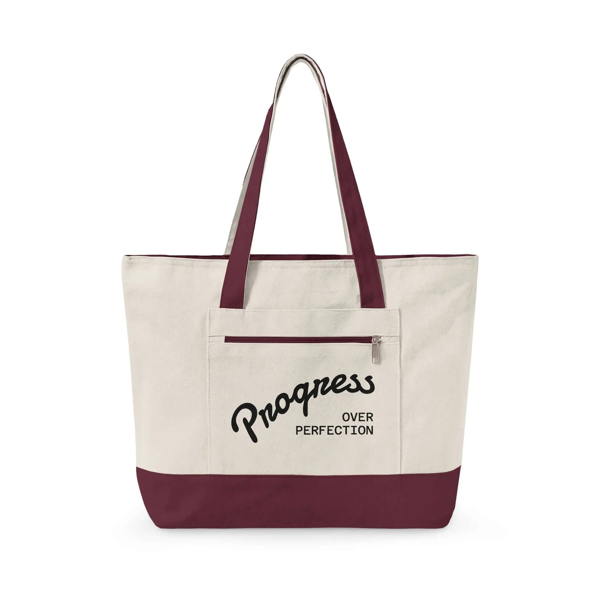 Progress Over Perfection Tote Bag |  Minimalist canvas tote bag with black straps and zipper pocket featuring the motivational quote “Progress Over Perfection” in bold black typography on a neutral cream background.